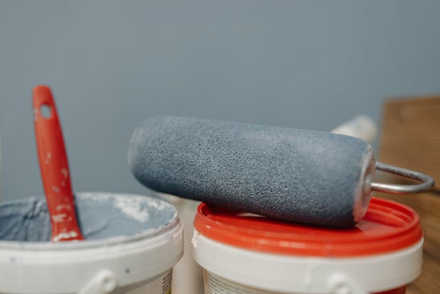 grey-paint-roller-on-paint-bucket